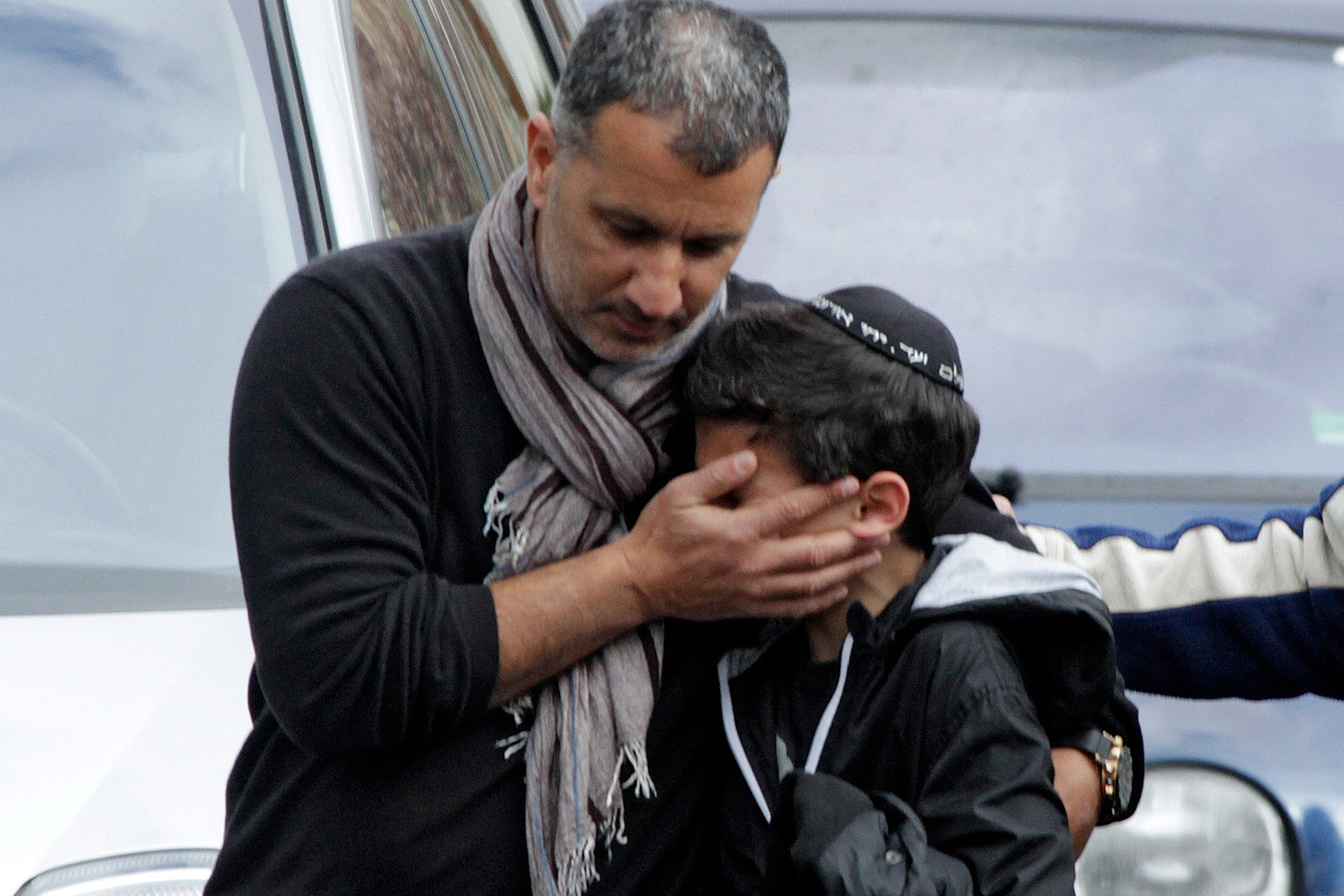Bild på ung pojke i kippa som tröstas av en man efter terrorattentatet i en skola i Toulouse 2012